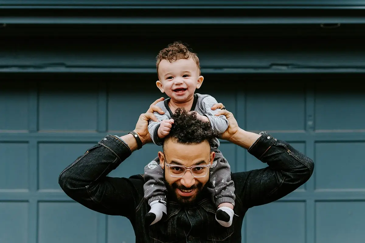 Man carrying smiling toddler