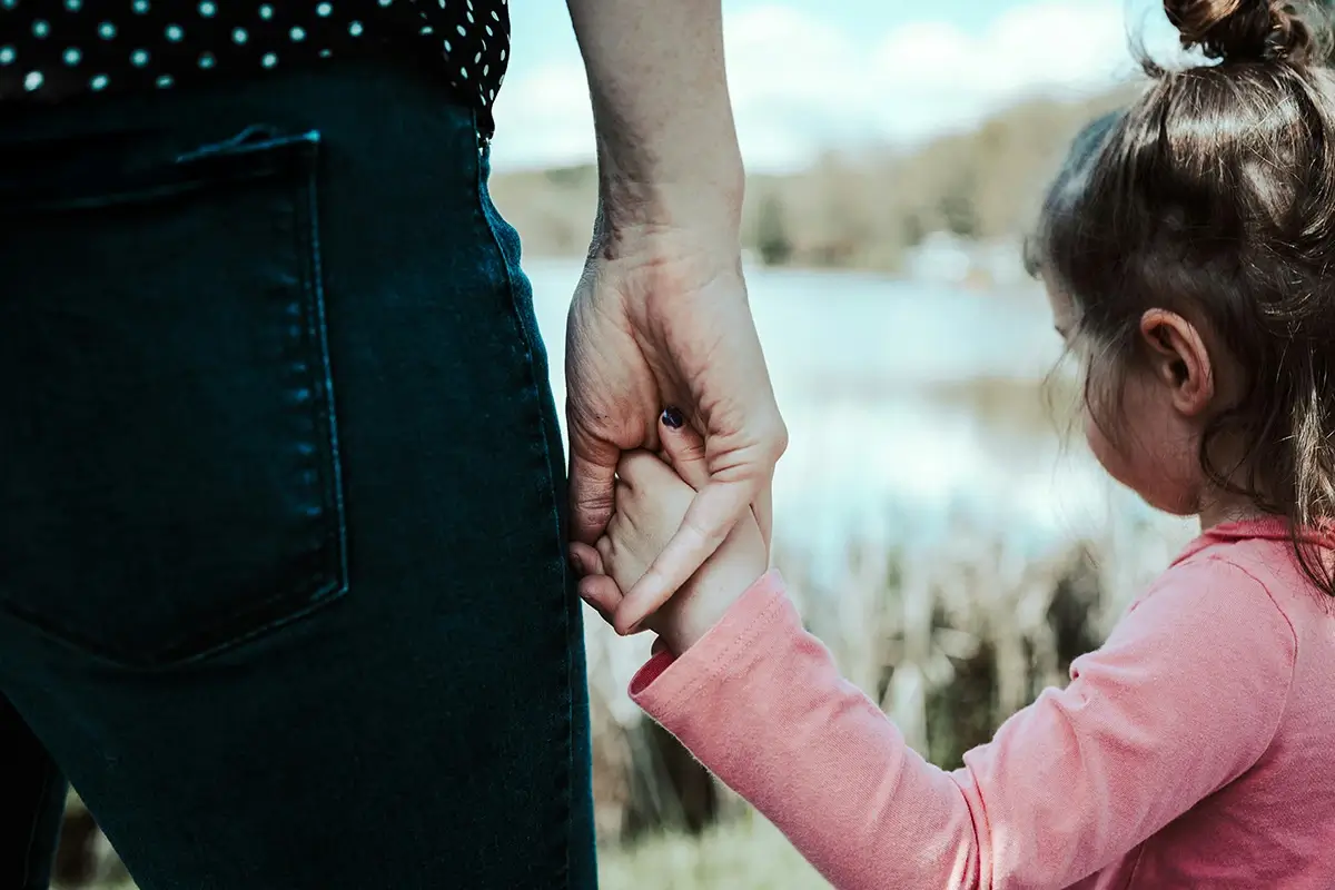 A father holding his young daughter's hand