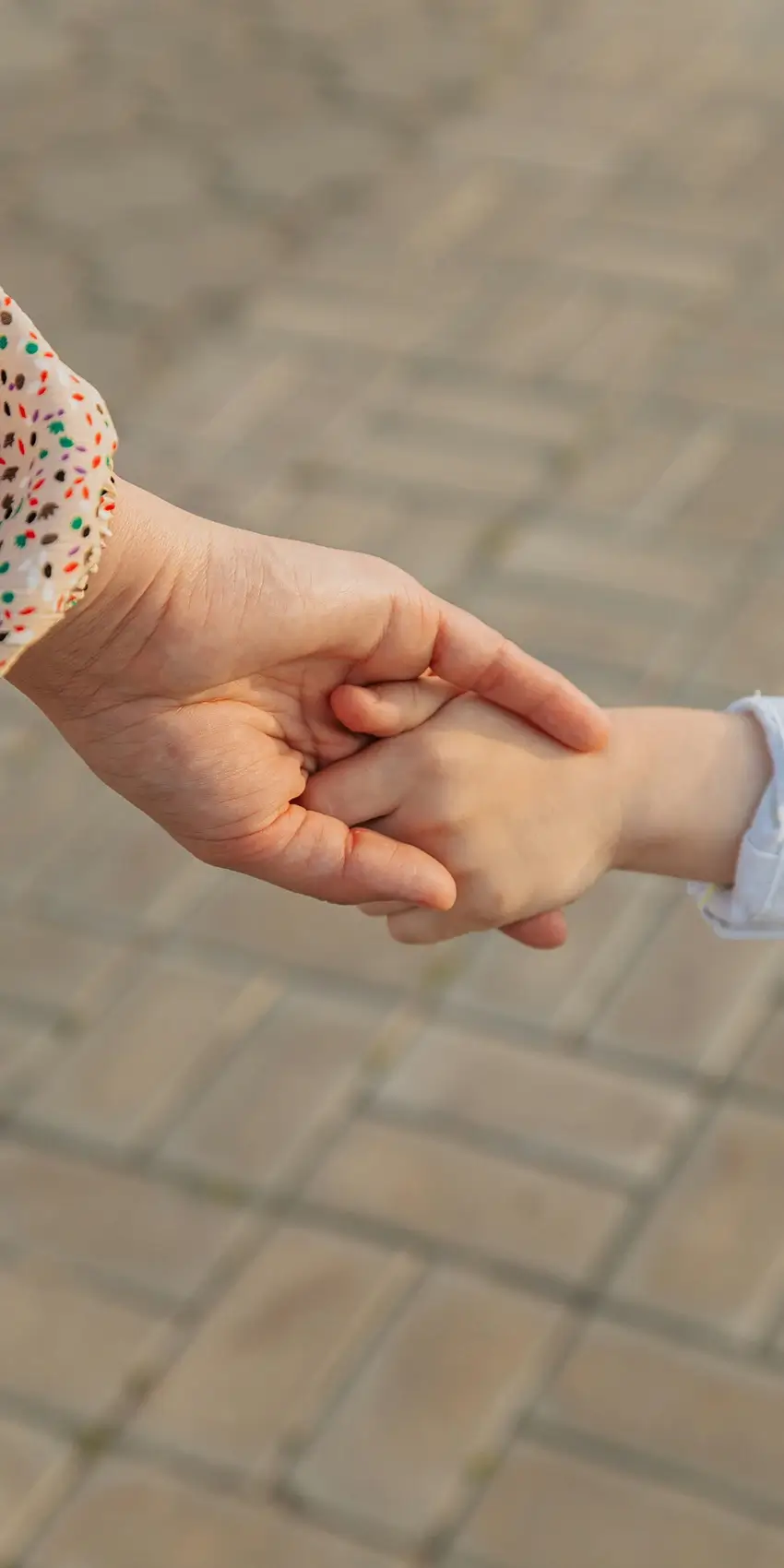 Woman holding child's hand